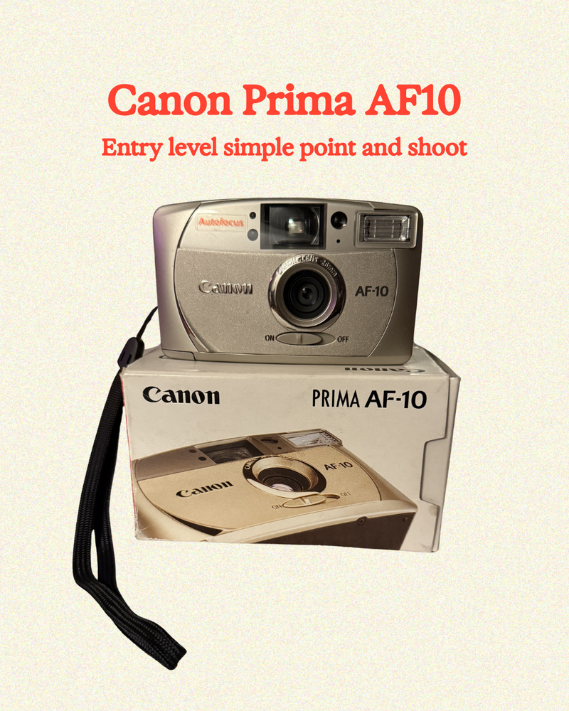 Canon Prima AF10 camera and its packaging on a beige background